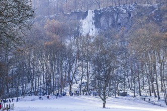 Numerous day trippers hike to the Urach waterfall full of bizarre ice formations, frozen at low