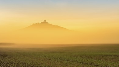 The silhouette of Wachsenburg Castle rises out of the fog at sunrise, Castle of the Three Gleichen