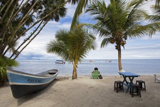 Sandy beach beach, coconut trees and boat at Playa Blanca, Izabal Department, Guatemala