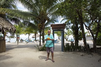 German manager, 67 years old, at Playa Blanca with a coconut, Izabal Department, Guatemala