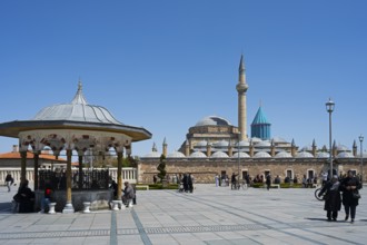 Mosque with minaret and domes under clear sky, traditional atmosphere with people in the