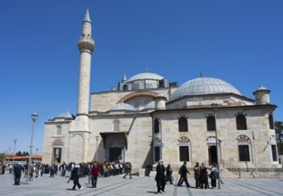 Visitors enter a historic mosque with several domes and minarets, prayer in front of the mosque,