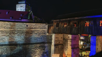 Historic bridge and castle structure, colourfully illuminated at night, Kronach glows, Franconian