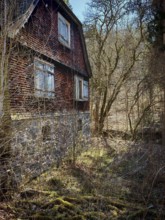 Abandoned old house in the forest, surrounded by trees and scrub, Frankenwald nature park Park