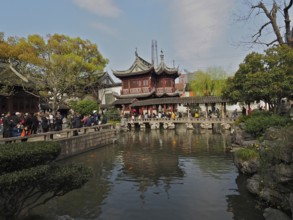 Traditional buildings surround a pond with carp and gardens, Yuyuan Garden, Shanghai, China