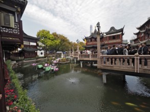 Bridge over a pond with historical background and buildings, Yuyuan Garden, Shanghai, China