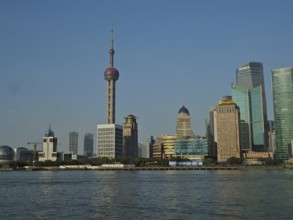 Panorama of a modern skyline of Huangpu Jiang with television tower and water in the foreground,