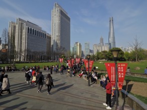 A busy municipal park with people and skyscrapers, Shanghai Tower, in the background, Shanghai,