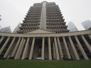 Large symmetrical building with pillars and lawn in an urban environment, Pudong, Shanghai, China
