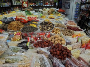 Various dried foods and spices in packaging and trays at a busy market, Wet Market, French
