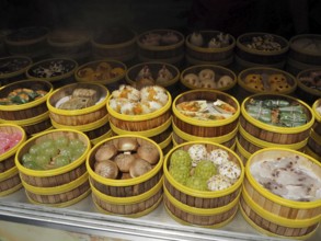 Different types of dim sum carefully arranged in bamboo steamers at a wet market, French
