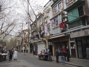 Street scene with pedestrians and residential buildings reflecting everyday life in a lively city,