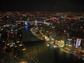 Night view of illuminated city with river and bridges forming a glowing skyline, Shanghai, China
