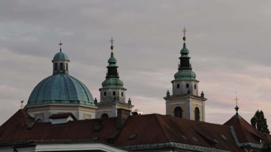 Three church towers and a dome rise against a cloudy evening sky, Piran, Slovenia