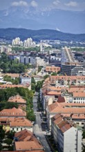 View of urban architecture with distinctive red roofs and mountain landscape, Ljubljana, Slovenia