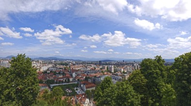 Panoramic view of an urban landscape under blue sky with mountains in the background, Ljubljana,