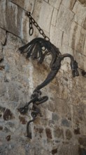 Ancient metal sculpture, Ljubljana dragon hanging on a stone wall surrounded by historic
