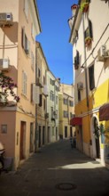 A narrow, colorful alley in a Mediterranean town in bright sunshine, Piran, Slovenia
