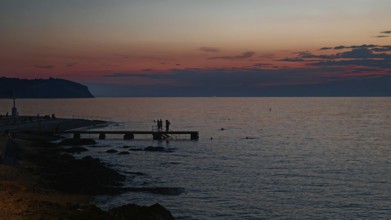A peaceful sunset with silhouettes of people by the sea, Izola, Slovenia