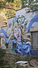 Wall art of a mythical woman surrounded by vivid colors and details, Pristina, Kosovo