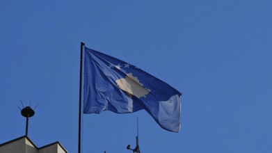 Close-up of a waving Kosovo flag against a clear blue sky, Pristina, Kosovo