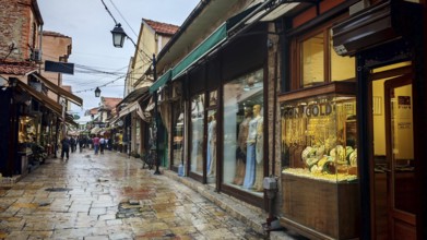 An old town alley with shops and wet pavement, Ohrid, North Macedonia