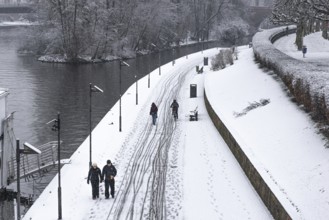 Only a few passers-by and cyclists move along the banks of the Main due to weather conditions.