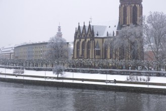 A passerby walks along the banks of the Main with an umbrella. Heavy snowfalls have caused another