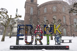 A passerby walks past St. Paul's Church in Frankfurt with an umbrella. Heavy snowfalls have caused