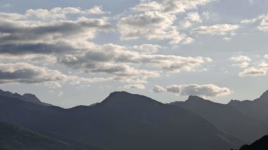 Mountain ranges in the background with clouds in the sky and a calm atmosphere, Peaks of the