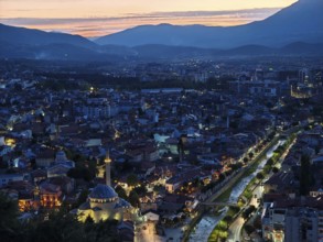Night scene of an illuminated city with river and mountains in the background, Prizren, Kosovo