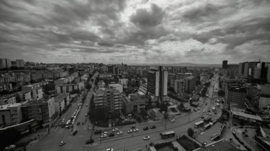 An urban street scene in black and white, with cloudy sky, Pristina, Kosovo