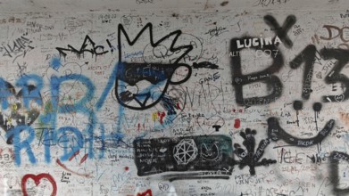 A wall with various graffiti and doodles in black and gray, Pristina, Kosovo