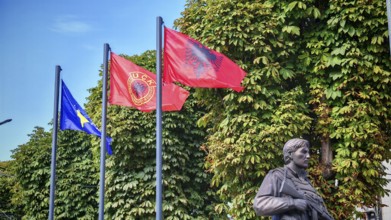 Memorial with flags of Kosovo, Albania and KLA against green background, Prizren, Kosovo