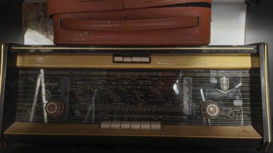 Old radio on a shelf with a brown suitcase above it, Kosovo