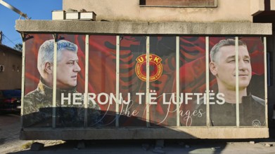 Portrait mural with KLA symbols war heroes on a building, Kosovo