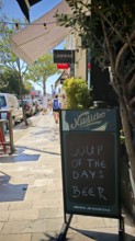 Funny street sign Chalkboard signs outside a café offering beer as soup of the day on a sunny day,