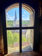View from a rustic window of a village with a church under a clear summer sky, Upper Franconia