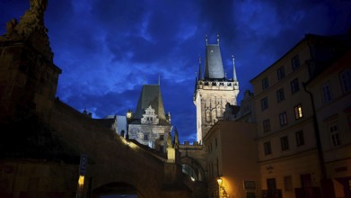 Night view of impressively illuminated historic towers and buildings, Prague