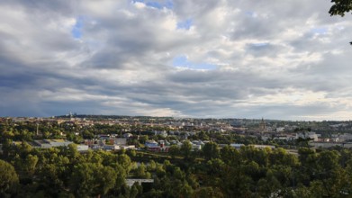Extensive urban landscape under dramatically cloudy sky with lots of greenery, Prague, Czech