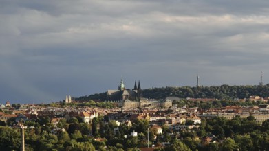 Panoramic view of a city with historic buildings under a cloudy sky, Prague