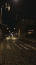 Dark, paved street with street lights leading into darkness, Prague, Czech Republic