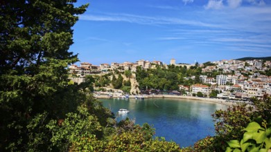 Panoramic view of a coastal town with boats and hills surrounded by clear skies, view of Ulcinj,