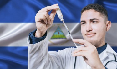 Doctor holding syringe on Nicaragua flag background. Medical professional holding syringe with