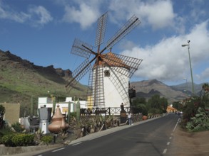 Traditional windmill along a road against a mountainous backdrop, Mogan windmill, Gran Canaria,