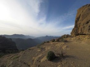 Wide, rocky landscape with views of distant mountains under blue sky, Roque Nublo, Gran Canaria,