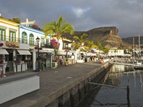 Picturesque harbor promenade with colorful buildings and palm trees, Puerto de Mogan, Gran Canaria,