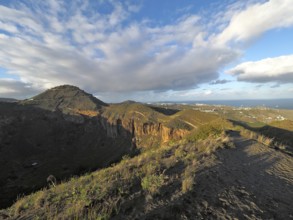 Range of hills under extended sky, widely visible sea in the background, Caldera de Bandama