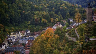 Idyllic village in an autumn landscape on a hill with a tower with mixed vegetation, Franconian