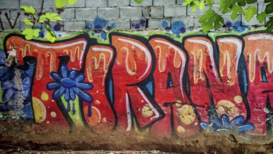 Graffiti with eye-catching colorful letters on a wall in an urban environment, city name Tirana,
